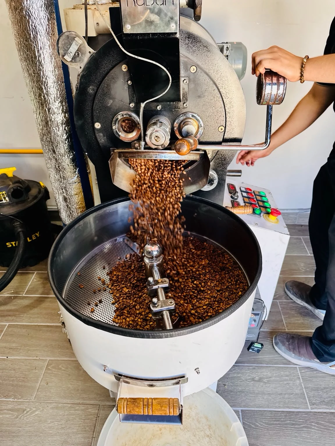 Freshly roasted coffee dropping from the Nordico roaster into the cooling tray in the new Nordico roastery in Costa Rica.